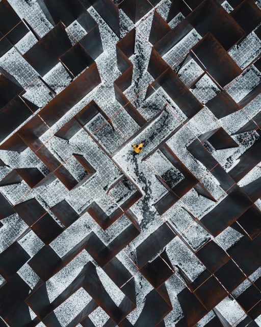 person in black pants walking on black and white concrete blocks