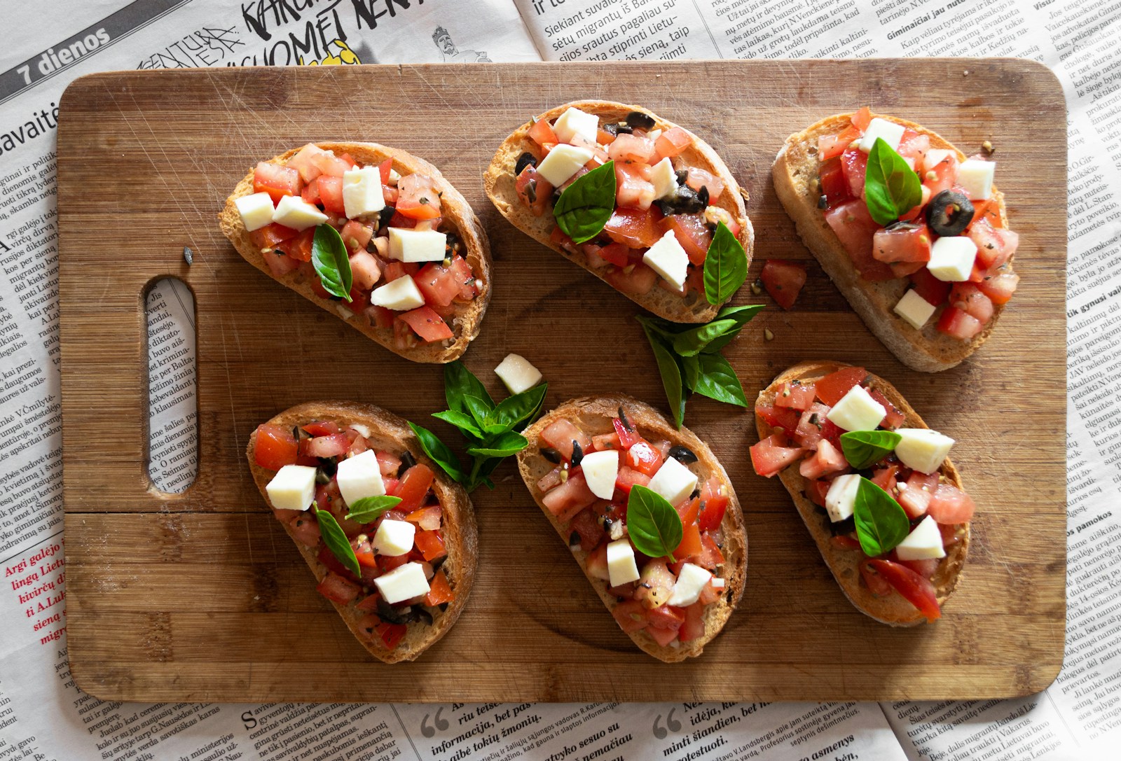 sliced tomato and green vegetable on brown wooden chopping board