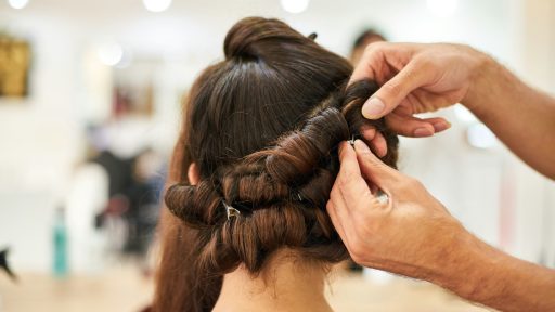 woman in blue shirt holding her hair