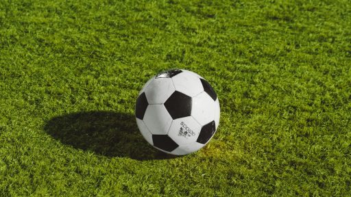 white and black soccer ball on grass field