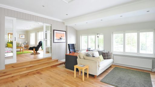 Spacious and bright modern living room with wooden floors and stylish furniture.