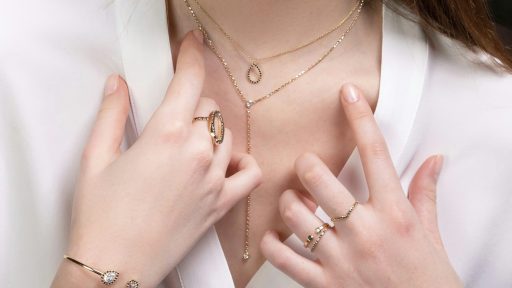 a close up of a person wearing rings and a necklace