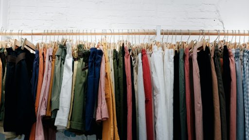 assorted-color clothes lot hanging on wooden wall rack