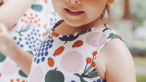 girl in white and green floral tank top wearing white sun hat