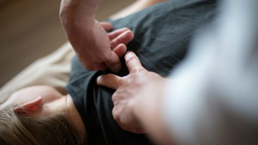 a woman laying on top of a bed holding a mans hand