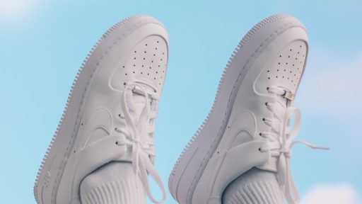 person wearing white nike sneakers
