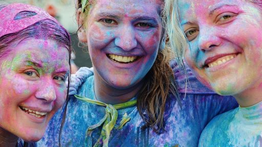 Vrouwen in zomerse festival outfits op een druk festivalterrein bij zonnig weer