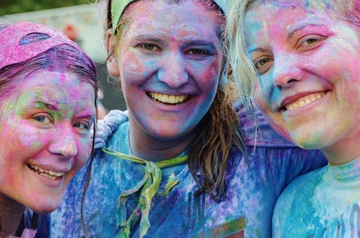 Vrouwen in zomerse festival outfits op een druk festivalterrein bij zonnig weer