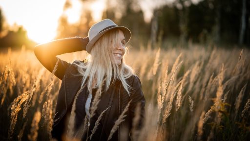 Vrouw die zonnebrandcrème aanbrengt op haar gezicht op een zonnige zomerdag