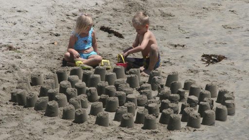 Kinderen spelen in het zand op het strand van Scheveningen op een zonnige zomerdag