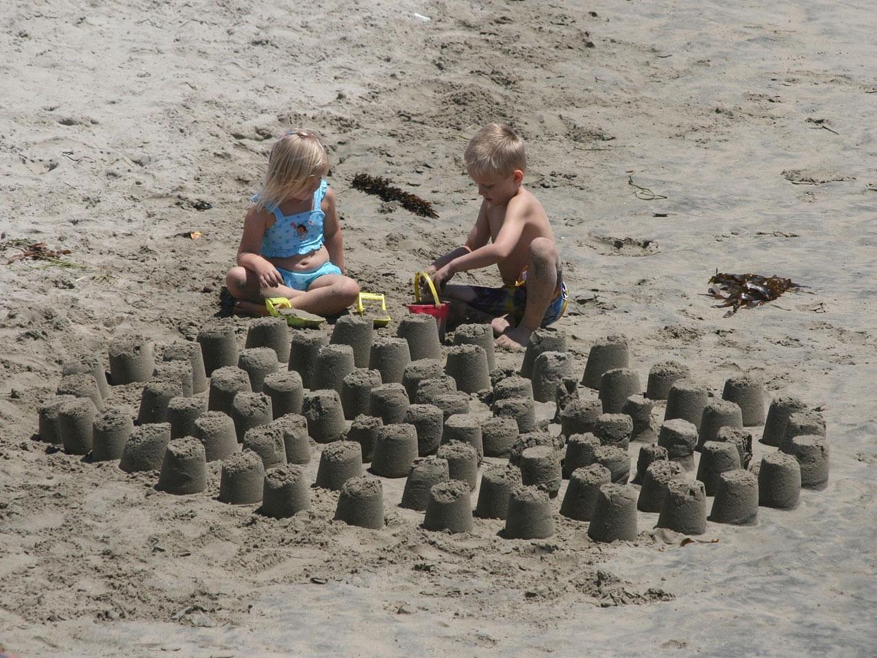 Kinderen spelen in het zand op het strand van Scheveningen op een zonnige zomerdag