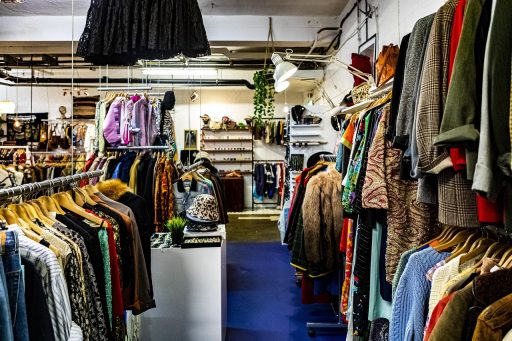 Kleurrijke rekken met vintage kleding in een kleine tweedehandswinkel