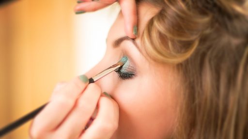 Vrouw die gezichtsserum aanbrengt voor de spiegel als onderdeel van haar huidverzorgingsroutine