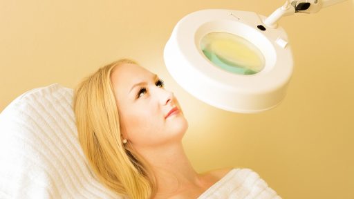 Vrouw die voorzichtig gezichtscrème aanbrengt op haar huid