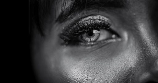 Vrouw die peinzend in de spiegel kijkt en haar gezicht bestudeert