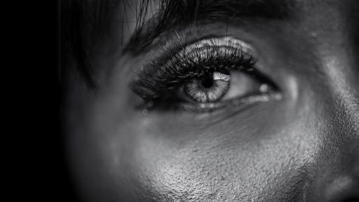 Vrouw die peinzend in de spiegel kijkt en haar gezicht bestudeert