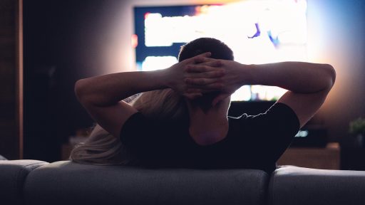 Vrouw kijkt geconcentreerd naar een streamingserie op haar laptop