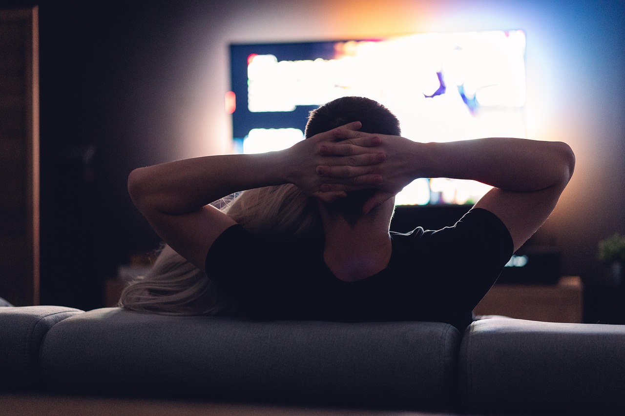 Vrouw kijkt geconcentreerd naar een streamingserie op haar laptop