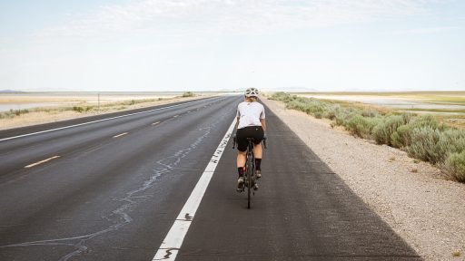Vrouw op racefiets tijdens een rit op een rustige weg