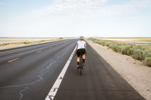 Vrouw op racefiets tijdens een rit op een rustige weg