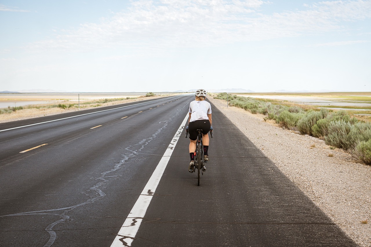 Vrouw op racefiets tijdens een rit op een rustige weg
