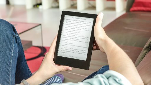 Vrouw leest geconcentreerd een boek op de bank