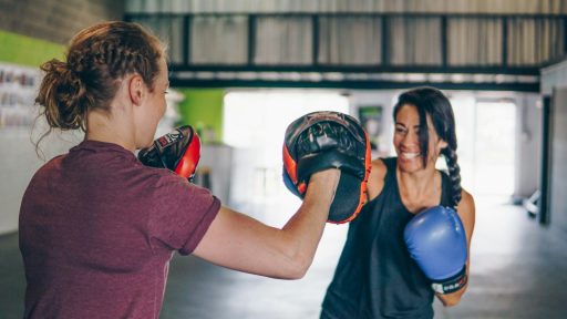 man in red t-shirt wearing blue boxing gloves